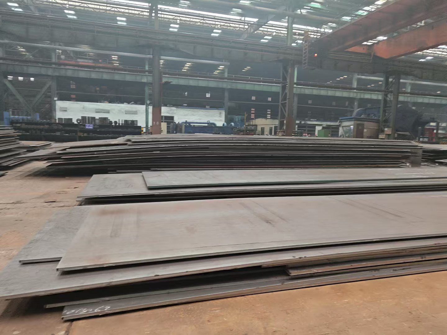 Carbon steel plates stacked in warehouse, surface condition checked during customer inspection