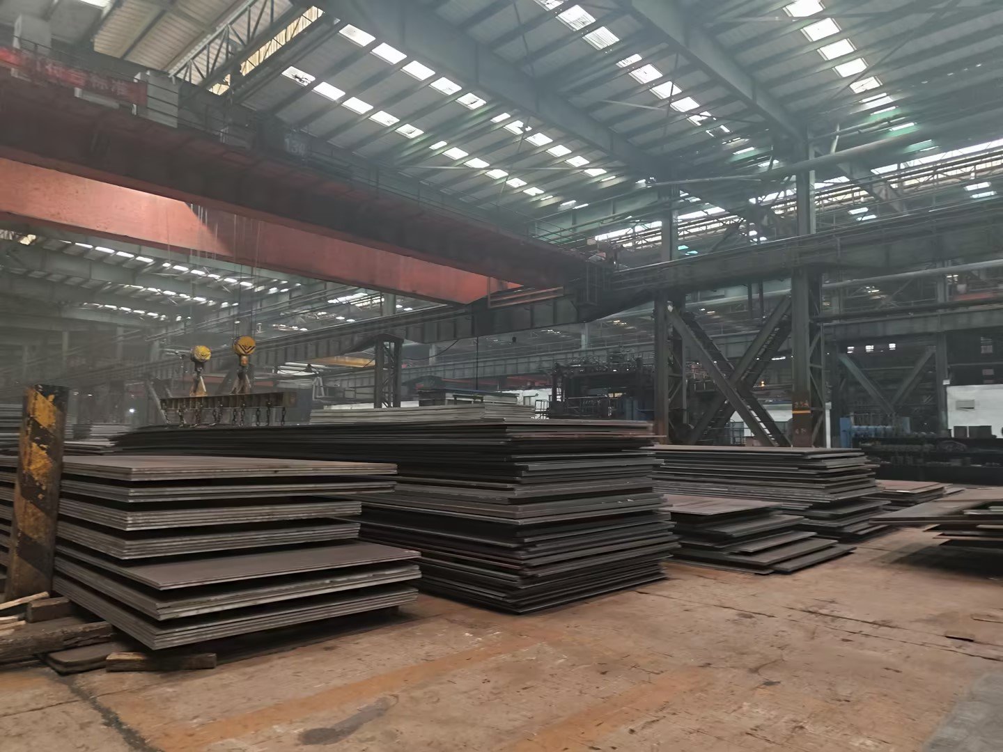 Steel plate warehouse with overhead crane and stacked S355NL plates ready for export